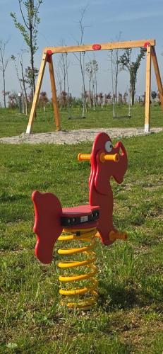 a playground with a dinosaur seat in a park at Agricampeggio AL CIELO STELLATO in Valeggio sul Mincio