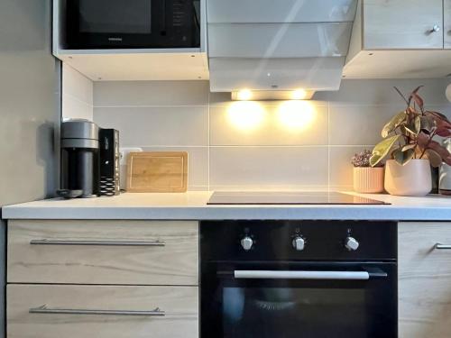 Il comprend une cuisine équipée d'une cuisinière noire et d'un four micro-ondes. dans l'établissement Home in Paris! sun, free parking, garden!, à Villejuif