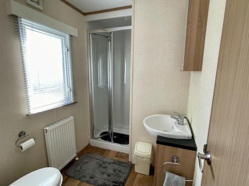 a bathroom with a toilet and a sink and a shower at South Bay Hideaway, Brixham in Brixham
