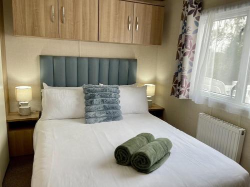 a bedroom with a bed with two towels on it at South Bay Hideaway, Brixham in Brixham