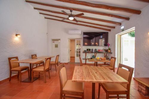 a dining room with wooden tables and chairs at Penedo Escape Nature in Colares