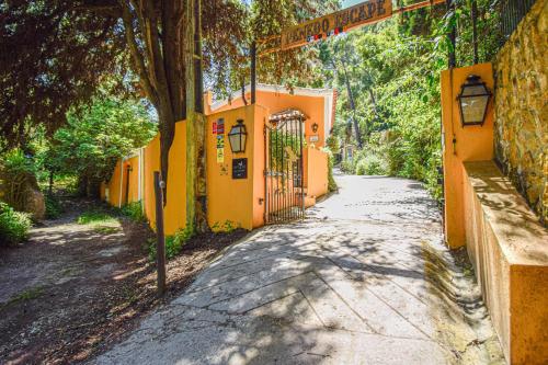 an empty street with a gate in an orange building at Penedo Escape Nature in Colares