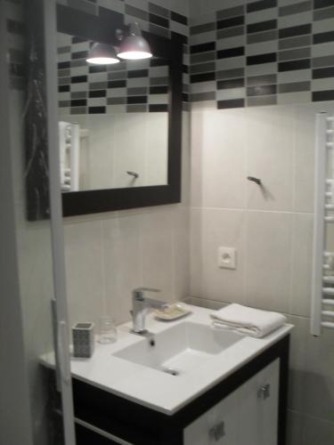 a bathroom with a sink and a mirror at Logis Hôtel Andreinia & Cabanes in Esterençuby