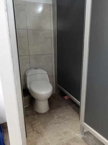 a bathroom with a white toilet in a stall at Auquis Hostel in Cusco