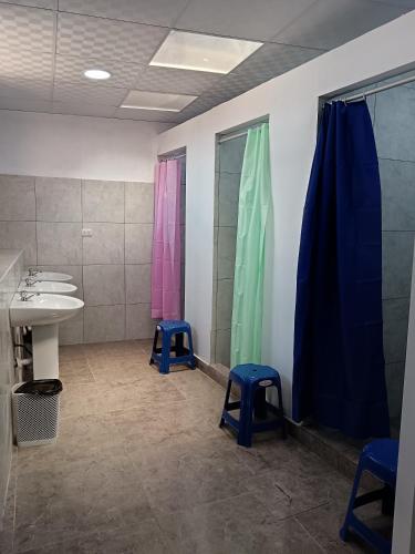 a bathroom with a sink and two blue stools at Auquis Hostel in Cusco