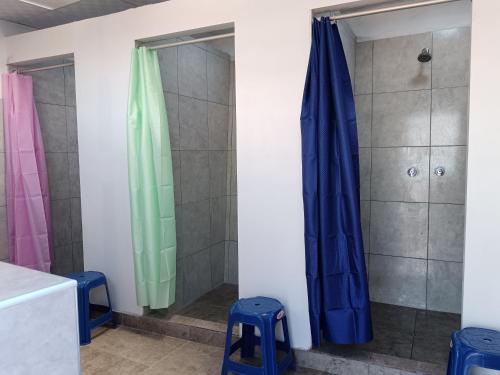 a bathroom with a shower and blue stools at Auquis Hostel in Cusco