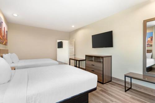 a bedroom with two beds and a flat screen tv at Clarion Pointe in Spring
