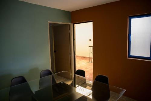 a dining room with a glass table and chairs at A 90m de Feria, Céntrico y Acogedor - Departamento A220-2 in Aguascalientes