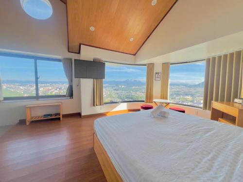 Schlafzimmer mit einem großen Bett und großen Fenstern in der Unterkunft Rocosy Villa DaLat in Khu Chi Lăng