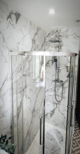 a shower in a bathroom with a marble wall at Taunton Retreat in Wilton