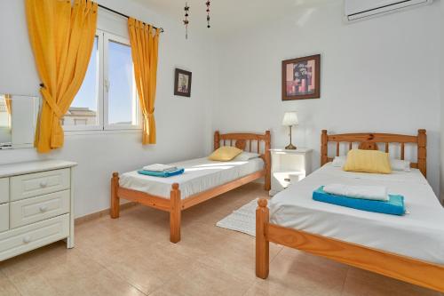 a bedroom with two beds and a window at El Escondite in Alcaucín