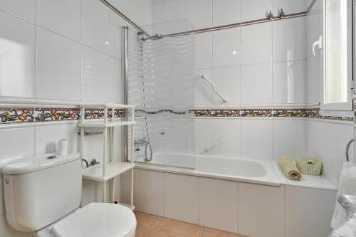 a bathroom with a toilet and a tub and a sink at El Escondite in Alcaucín