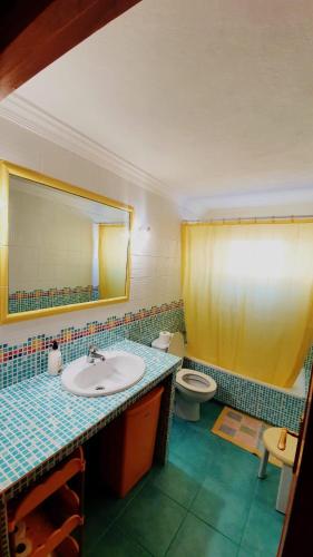 a bathroom with a sink and a toilet and a mirror at Casa Abuelo Antonio in El Cotillo