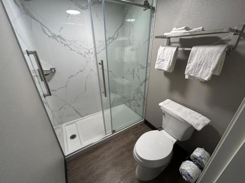 a bathroom with a toilet and a glass shower at Studio 6 Suites Gardena, CA in Gardena