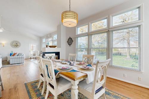 a dining room with a table and chairs and windows at Bear Trap Dunes --- 48 Sycamore St in Ocean View