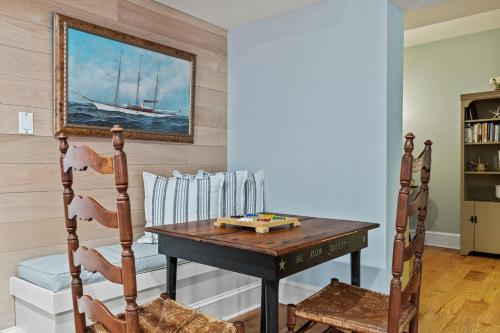 a dining room with a table and a boat painting at The Captain Stannard in Westbrook