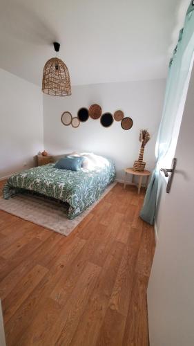 - une chambre avec un lit sur du parquet dans l'établissement appartement Le bohème, à Fère-en-Tardenois