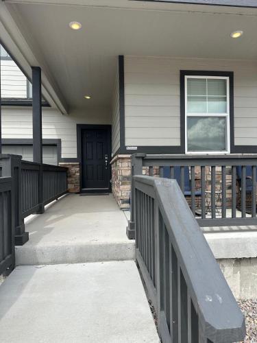 a front porch of a house with a black door at Guest Suite in Castle Rock in Castle Rock