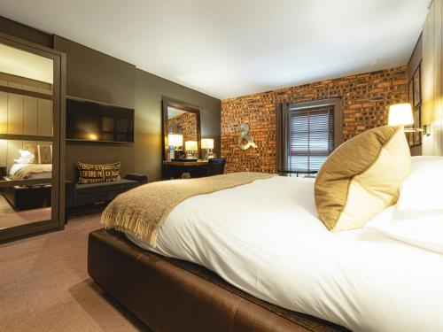 a bedroom with a large bed and a mirror at Dakota Edinburgh in Queensferry