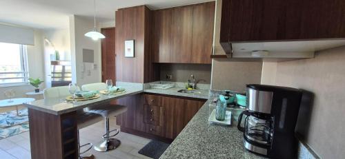 a kitchen with wooden cabinets and a counter top at Departamento Espacio Parque Calama in Calama