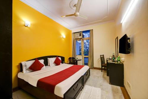 a bedroom with a bed with a yellow wall at Hotel City Centre Inn Near Nizamuddin Railway Station in New Delhi