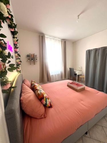 - une chambre avec un lit doté d'une couverture orange et d'une fenêtre dans l'établissement ValenStay - Cosy Love - Anzin - Netflix, à Anzin