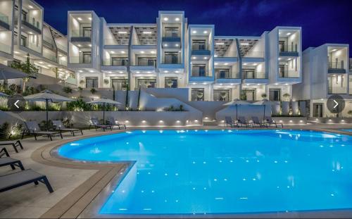 a swimming pool in front of a building at night at Artion Suites Nikiti in Nikiti