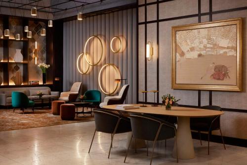 a lobby with a table and chairs and mirrors at NH Collection Sevilla in Seville