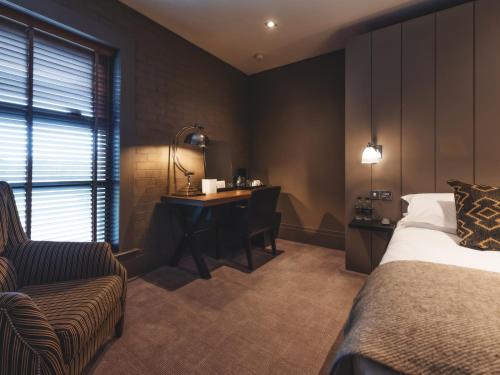 a hotel room with a bed and a desk and a chair at Dakota Edinburgh in Queensferry