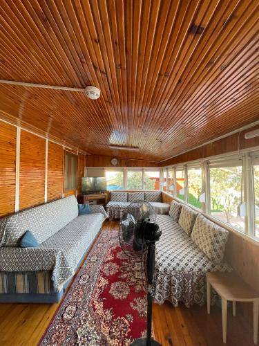 a living room with couches and a wooden ceiling at Demre Lukka Bungalow in Demre