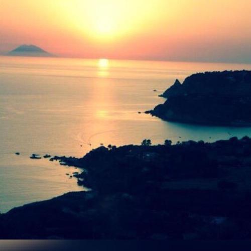 a sunset over a body of water with a island at Villa Grazia in Capo Vaticano