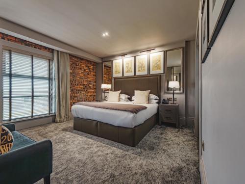a hotel room with a bed and a couch at Dakota Edinburgh in Queensferry