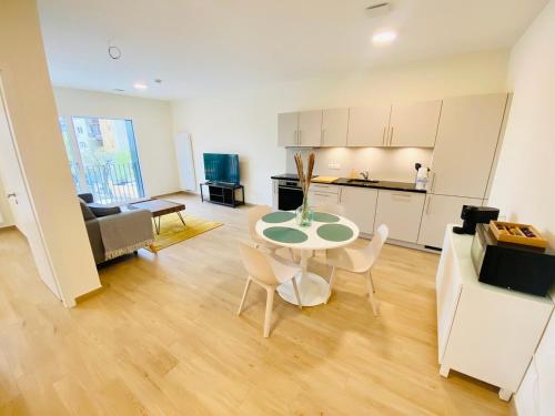 Una cocina y una sala de estar con mesa y sillas. en Luxury Flat in city center with free parking-HOL1, en Luxemburgo