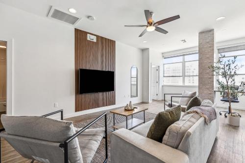 a living room with two couches and a flat screen tv at Entire High-Rise Apartment - 2BD in Baton Rouge