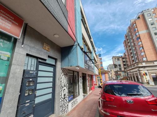 a red car parked in front of a building at Acogedor apartamento en el corazón de Duitama in Duitama