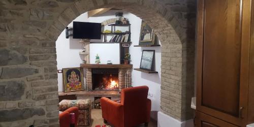a living room with an archway with a fireplace at La Casetta di Gino e Marcella in Sassoferrato
