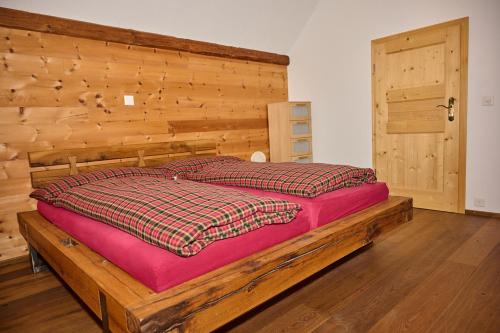a bed in a room with a wooden wall at Ferienhaus Luisa in Bad Ragaz