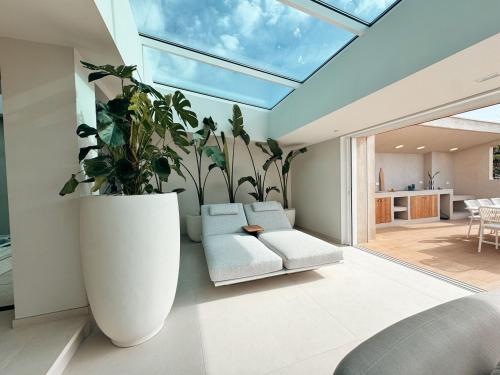 un salon avec un grand pot de plantes dans l'établissement Villa la corniche pieds dans l eau, aux Issambres