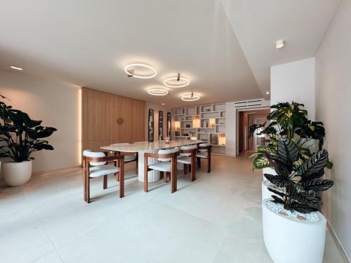 une salle à manger avec une table et des plantes dans l'établissement Villa la corniche pieds dans l eau, aux Issambres