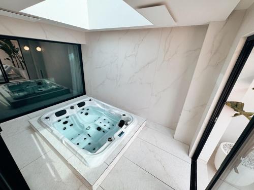 La salle de bains d'angle est pourvue d'une baignoire. dans l'établissement Villa la corniche pieds dans l eau, aux Issambres