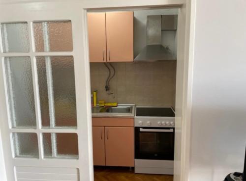a kitchen with a sink and a stove top oven at Palma Baosici in Baošići
