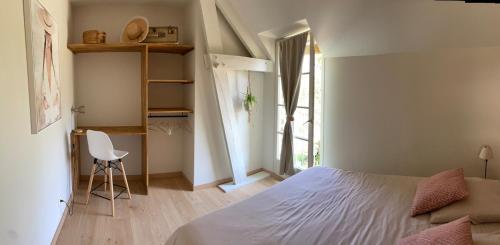 une chambre avec un lit, un bureau et une chaise dans l'établissement Gîte 5 personnes le bas du bois, à Moitron-sur-Sarthe