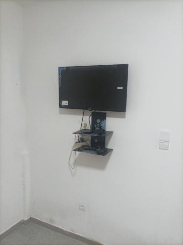 telewizor z płaskim ekranem wiszący na białej ścianie w obiekcie Le Studio w mieście Lomé