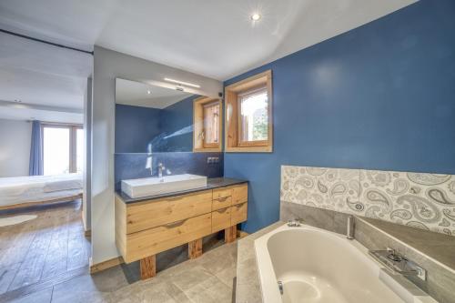 a blue bathroom with a tub and a sink at Chalet face au Mont-blanc in Sallanches