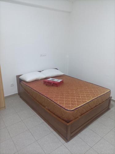 łóżko z drewnianą ramą w pokoju w obiekcie Le Studio w mieście Lomé