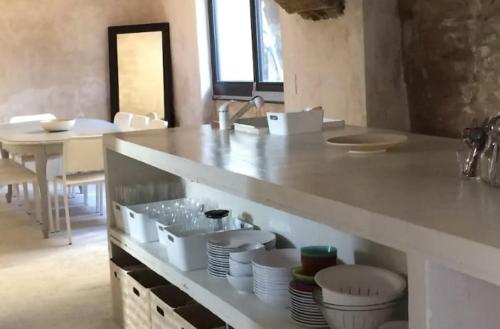 une cuisine avec un comptoir avec des bols et des assiettes dans l'établissement Maison exceptionnelle au coeur de Gordes avec piscine privée et vue panoramique, à Gordes