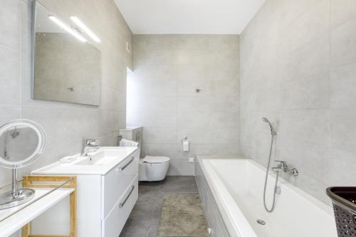 a bathroom with a sink and a tub and a toilet at Fleur de Mai penthouse with large terrace in Gzira in Taʼ Xbiex