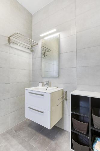 a white bathroom with a sink and a mirror at Fleur de Mai penthouse with large terrace in Gzira in Taʼ Xbiex