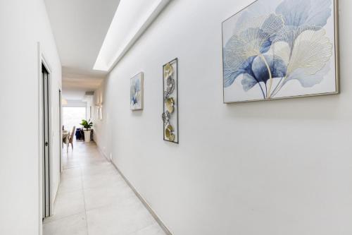 a hallway with paintings on the walls at Fleur de Mai penthouse with large terrace in Gzira in Taʼ Xbiex