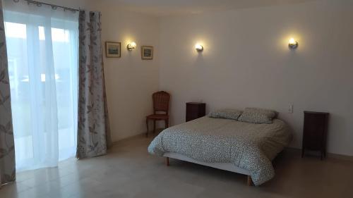 une chambre avec un lit et une chaise dedans dans l'établissement Belle Maison à MESLAND, à Mesland
